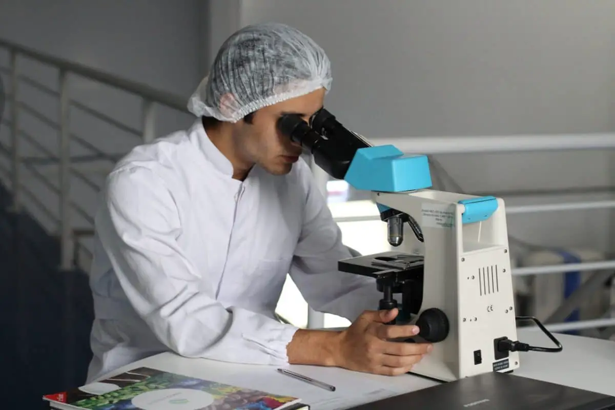 Man with biology degree using a microscope